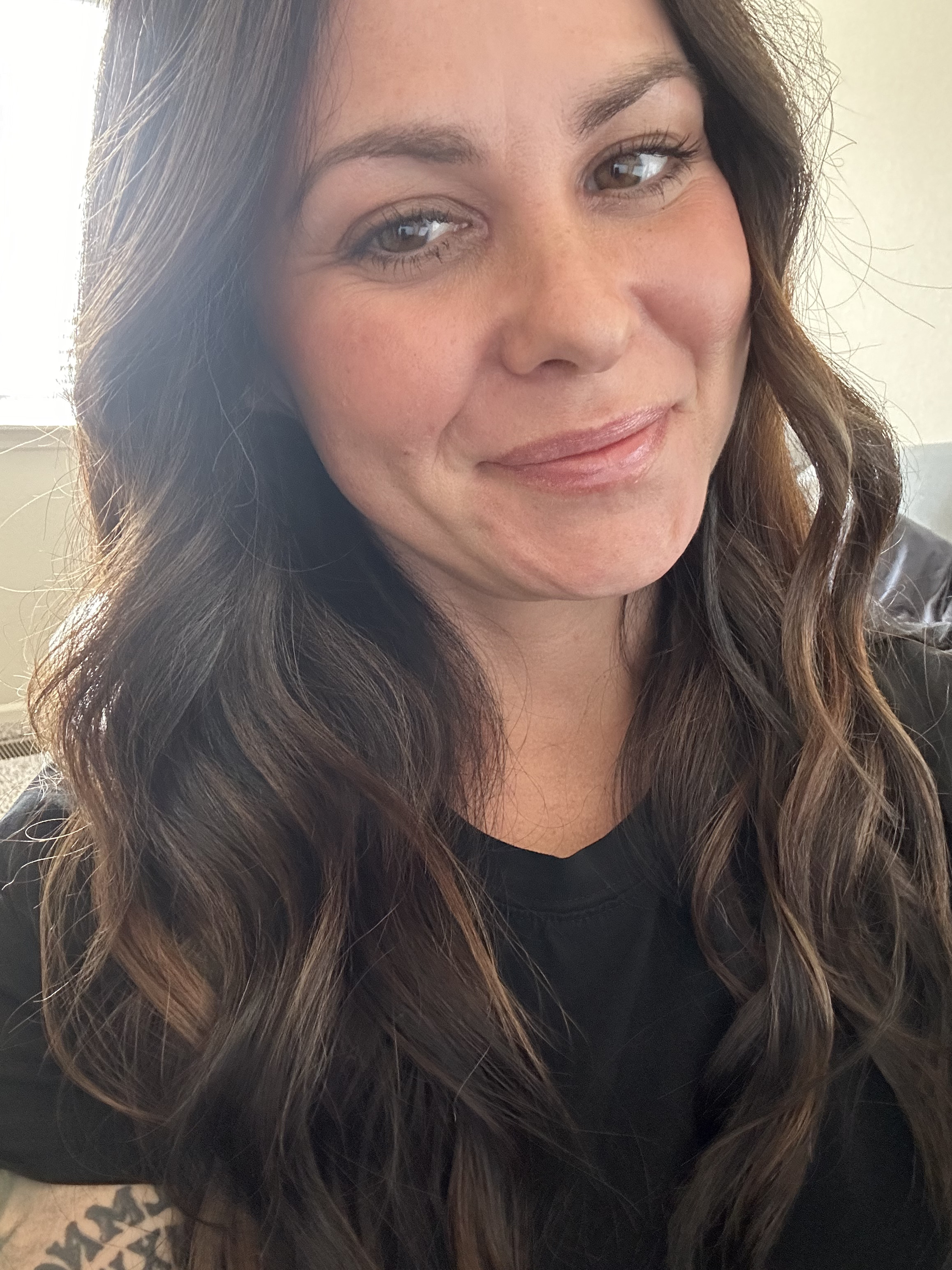 Courtney Orr with curly hair smiling at home in Kansas